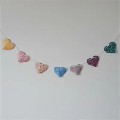 Origami heart garland hanging on the wall