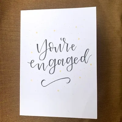 You're Engaged! on white card with gold