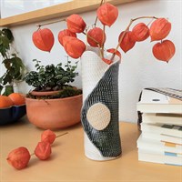 Blue/green single buttoned ceramic vase in room setting