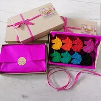 Open box of unicorn crayons with gift wrapped boxes surrounding. gallery shot 1