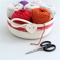 Cotton rope bowl with pink fabric trim full of balls of wool