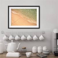 Photo art print 'Footsteps in the Sand' shown framed in a room setting