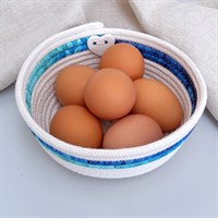 Rope bowl with blue fabric trim filled with eggs