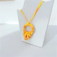 Yellow fabric pendant necklace hanging on a display stand
